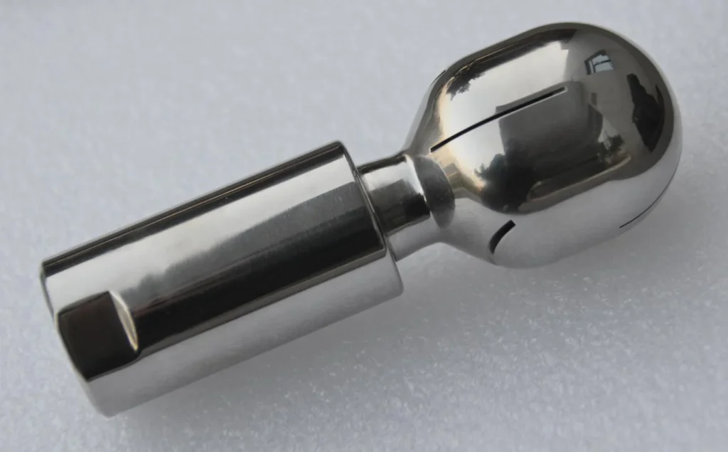 Rotary self-driven cleaning ball for fluid bed and coating machine cleaning