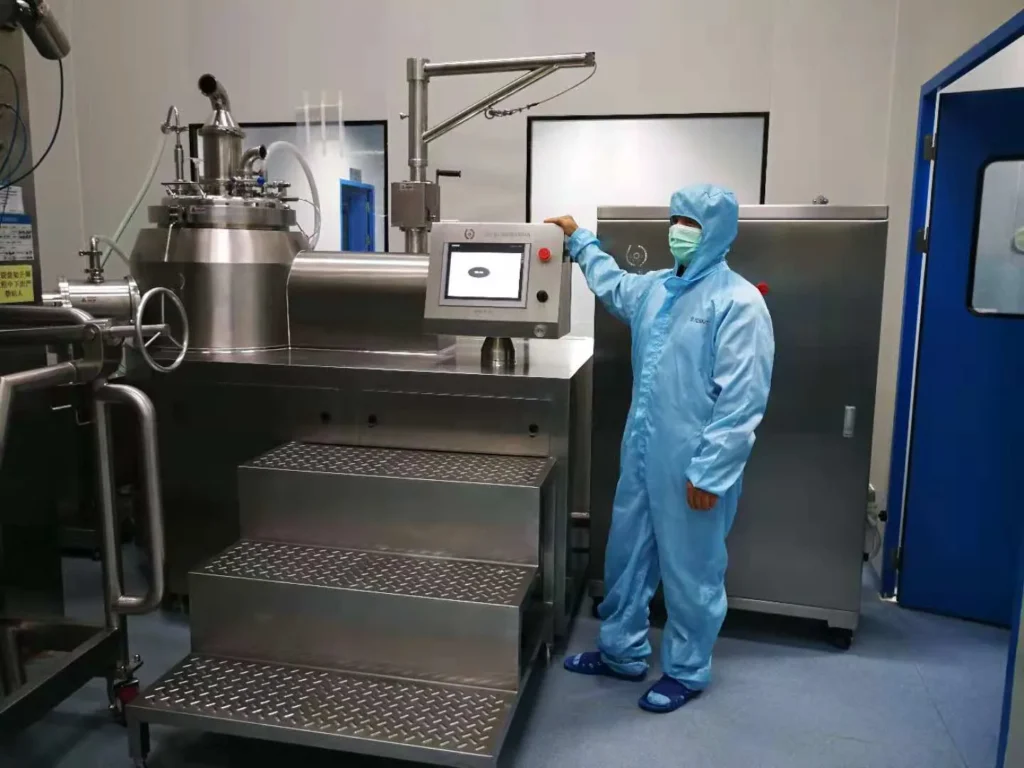 Engineer operating granulation line HMI in clean room
