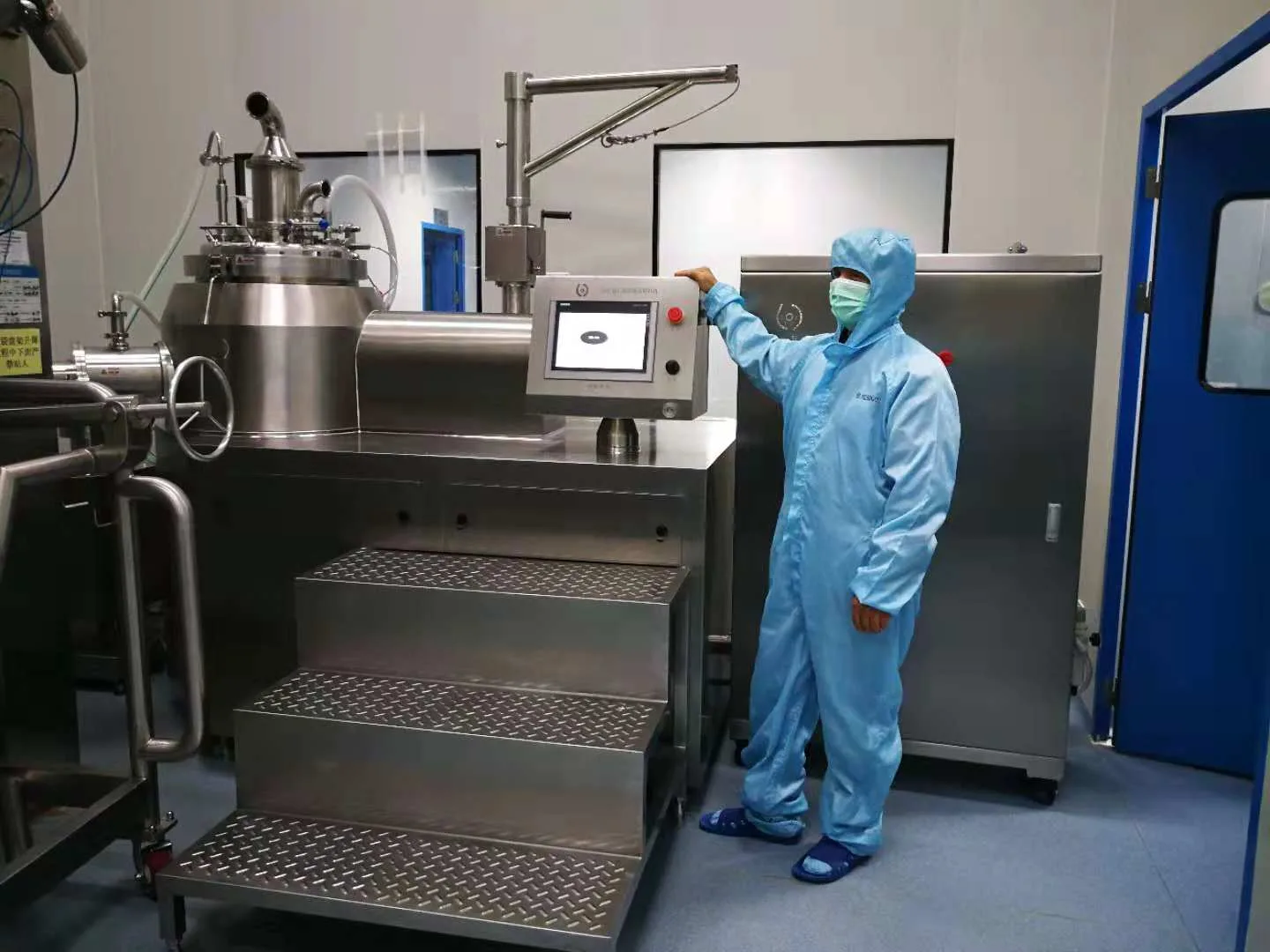 Engineer operating the granulation line HMI in clean room