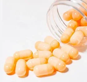 Amber translucent plant based capsules spilling from glass jar